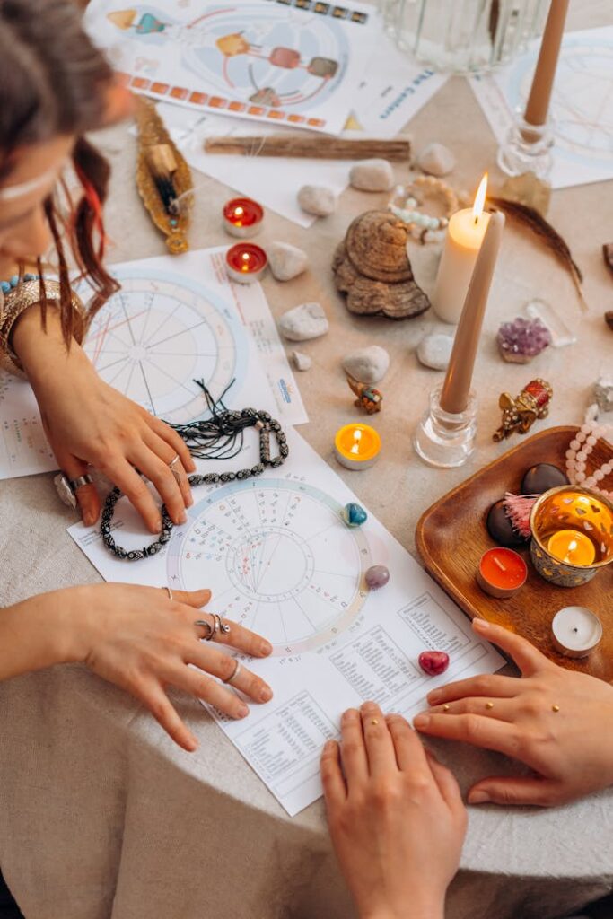 Mastering the First Impression: Your intriguing post title goes here Hands arranging astrology charts with candles and crystals on a table for a spiritual ritual.